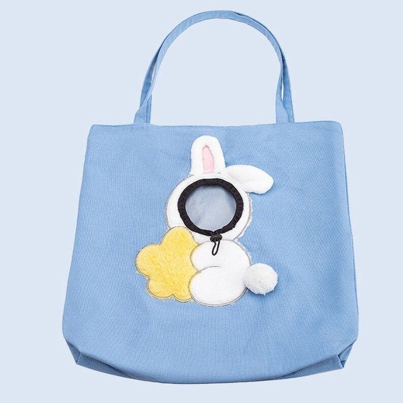 Cute plush toy peeking out pet bag